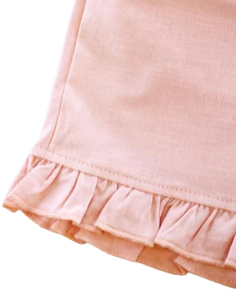 Close-up of a pink skirt with ruffled hem on a white background
