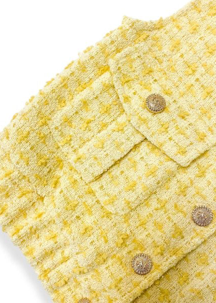 Yellow textured fabric with button details on a white background
