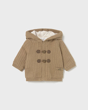 Brown knitted baby coat with hood and button details on a white background