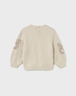 Beige sweater with heart designs on the sleeves against a white background