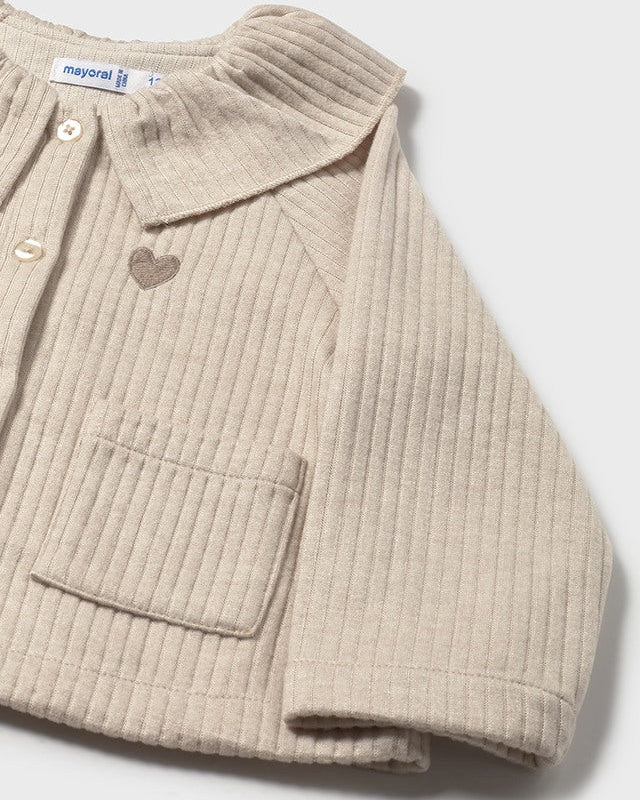 Beige ribbed sweater with a heart-shaped button on a light gray background