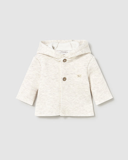 White baby jacket with buttons on a light gray background