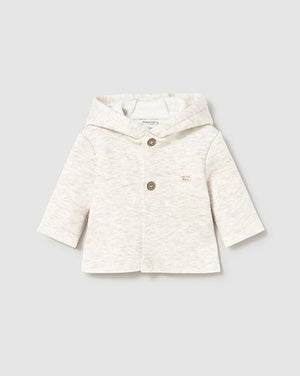 White baby jacket with buttons on a light gray background