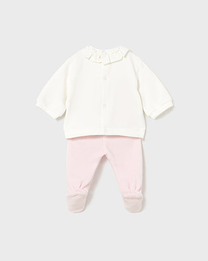 Baby outfit with white shirt and pink pants on a light gray background