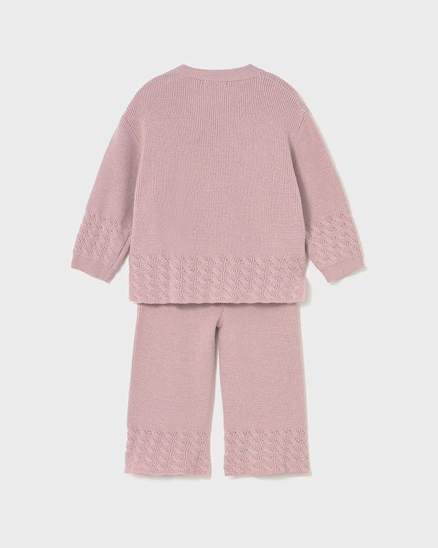 Pink textured sweater and pants set on a light gray background