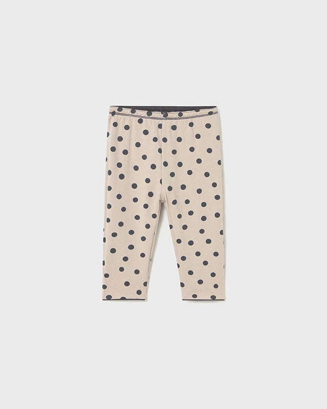 Beige leggings with black polka dots on a white background