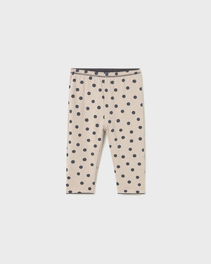 Beige leggings with black polka dots on a white background