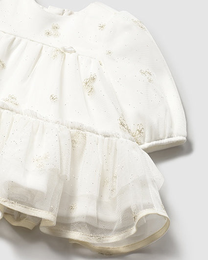 White dress with floral embroidery on a light gray background