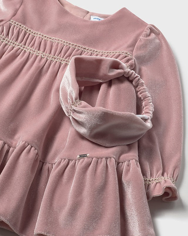 Pink velvet dress with ruffled details on a white background