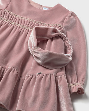 Pink velvet dress with ruffled details on a white background