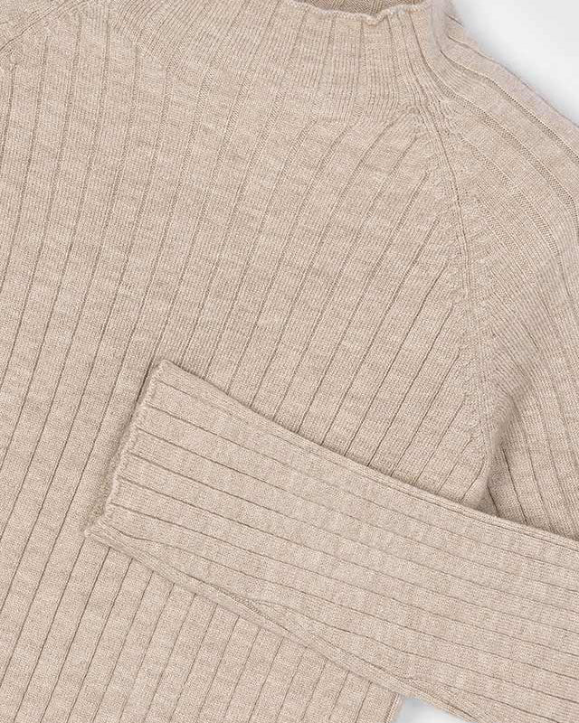 Close-up of a beige ribbed sweater on a white background