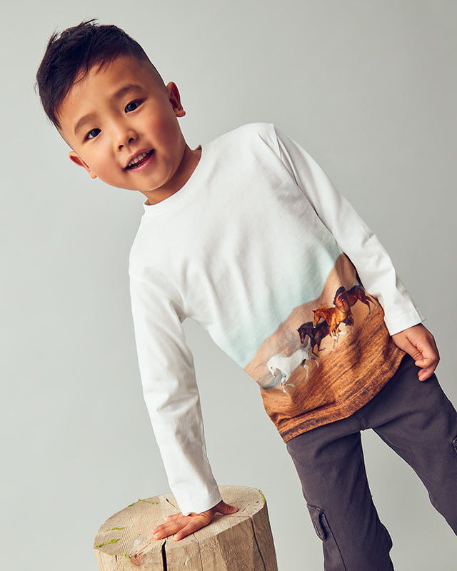 Child holding a wooden box with animal illustrations on a plain background