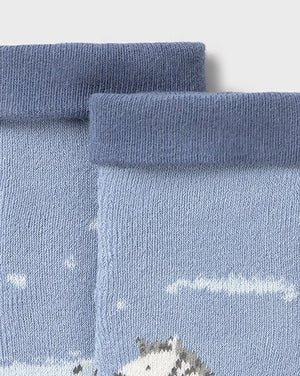 Close-up of blue socks with zebra pattern on a light gray background