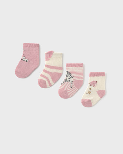 Set of four baby socks with pink and white patterns on a white background