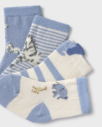 Set of three pairs of baby socks with animal patterns on a light gray background