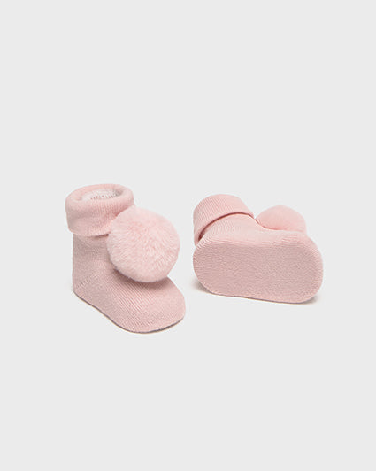 Pair of pink baby socks with heart details on a white background