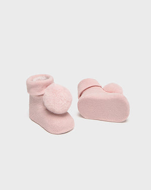 Pair of pink baby socks with heart details on a white background