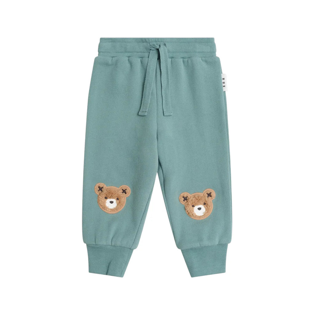 Teal children's sweatpants with bear faces on a white background