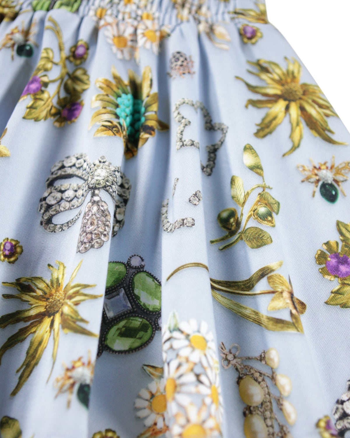 Close-up of a fabric with floral and jewelry patterns on a white background