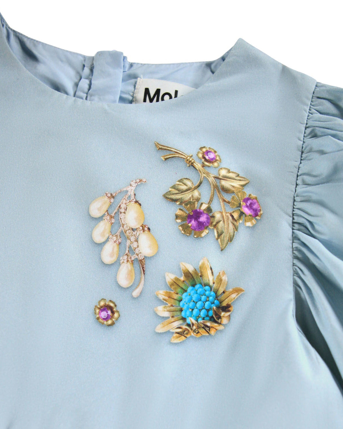 Set of brooches on a light blue fabric background