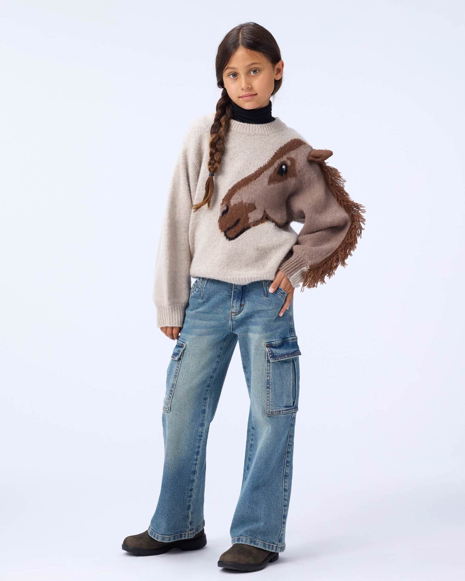 Person wearing a sweater with a horse design on a white background