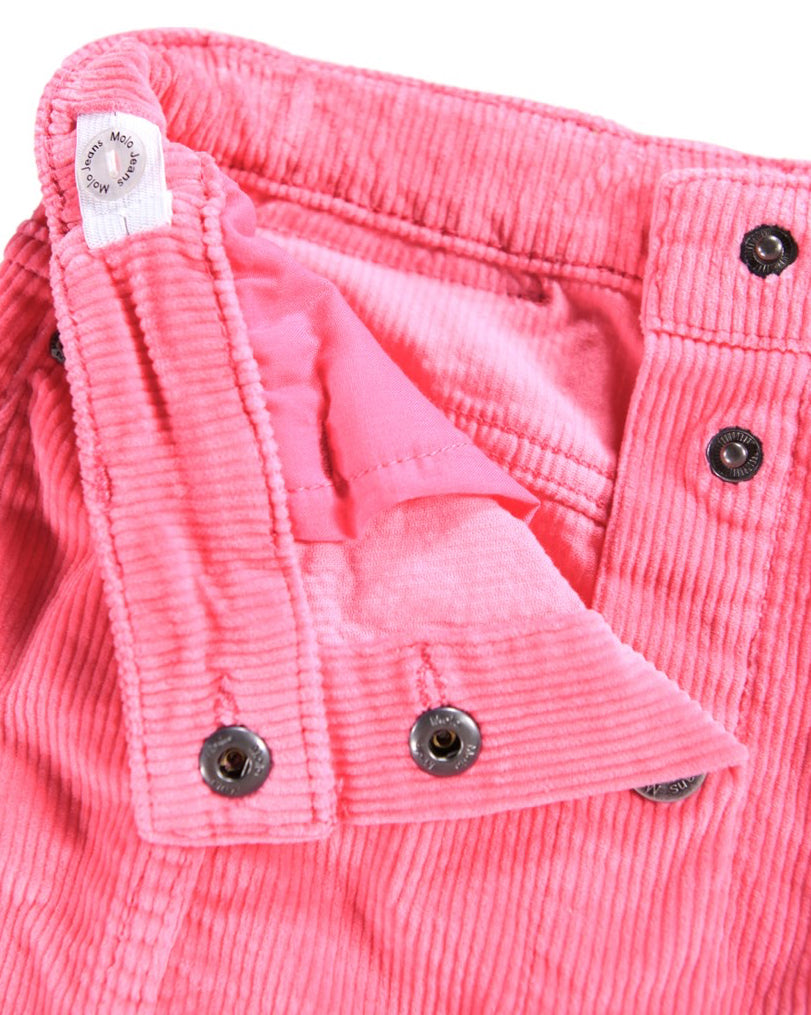 Close-up of pink corduroy pants with button details on a white background