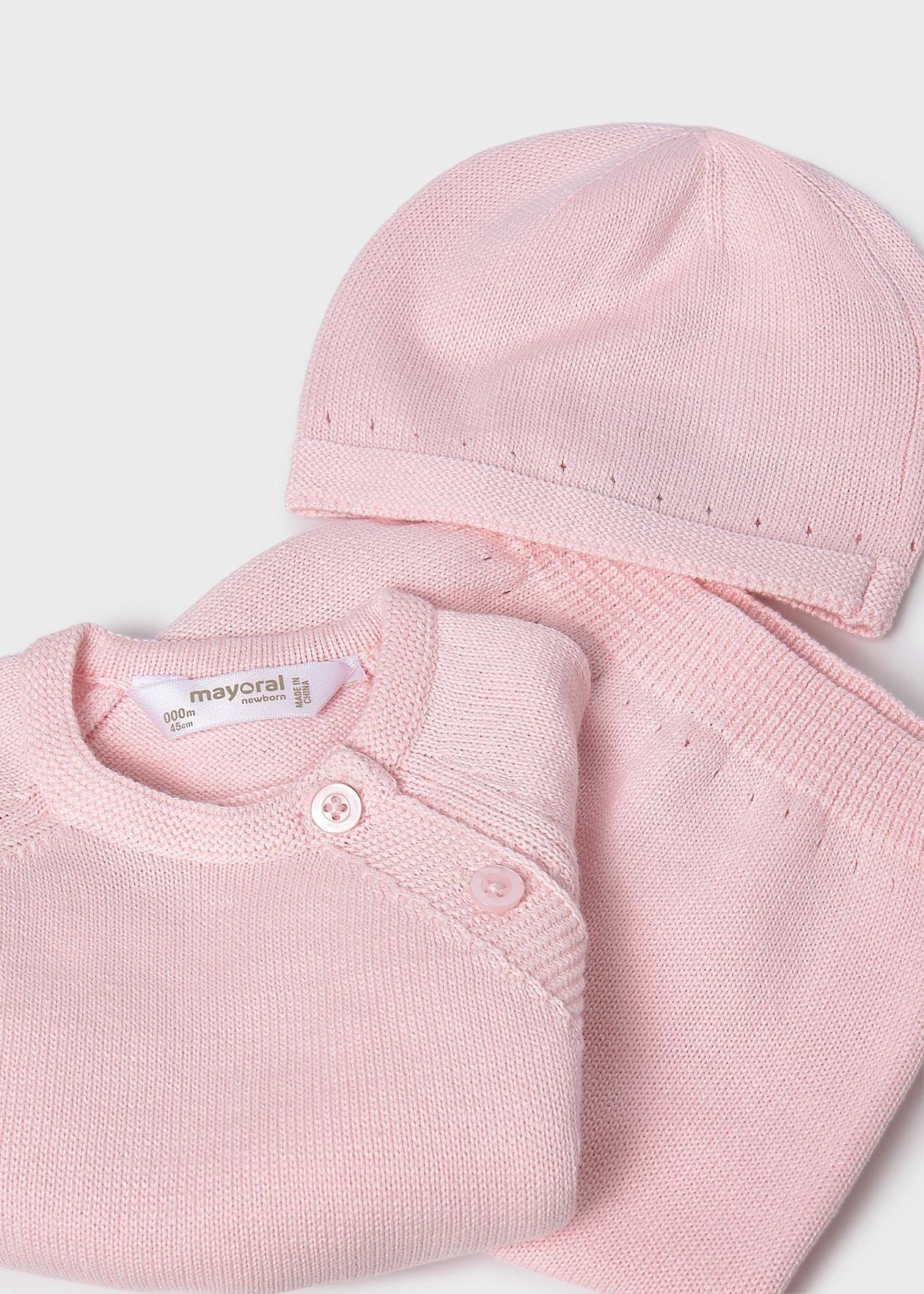 Pink baby outfit with a hat and shirt on a white background