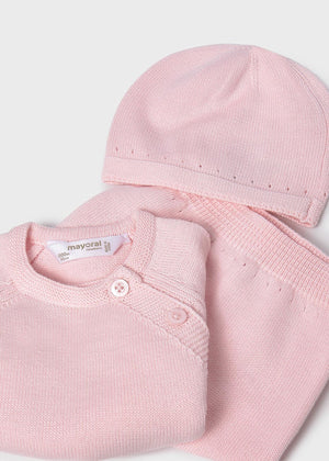 Pink baby outfit with a hat and shirt on a white background