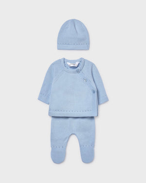 Blue baby outfit with top, pants, and hat on a light gray background