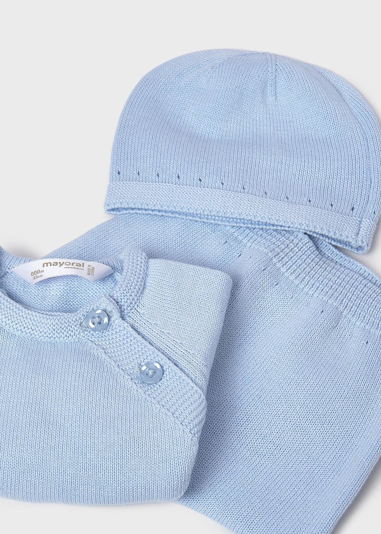 Folded baby outfit with light blue shirt and matching hat on a white background