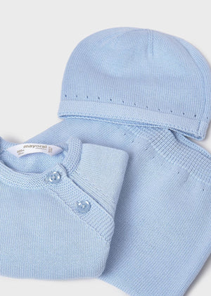 Folded baby outfit with light blue shirt and matching hat on a white background