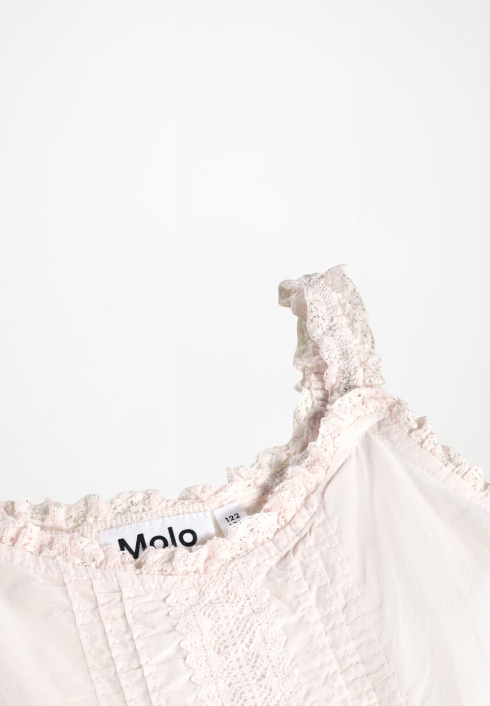 Close-up of a light pink lace garment with 'Molo' branding on a white background