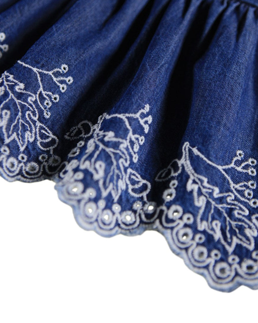 Blue fabric with white floral embroidery on a white background