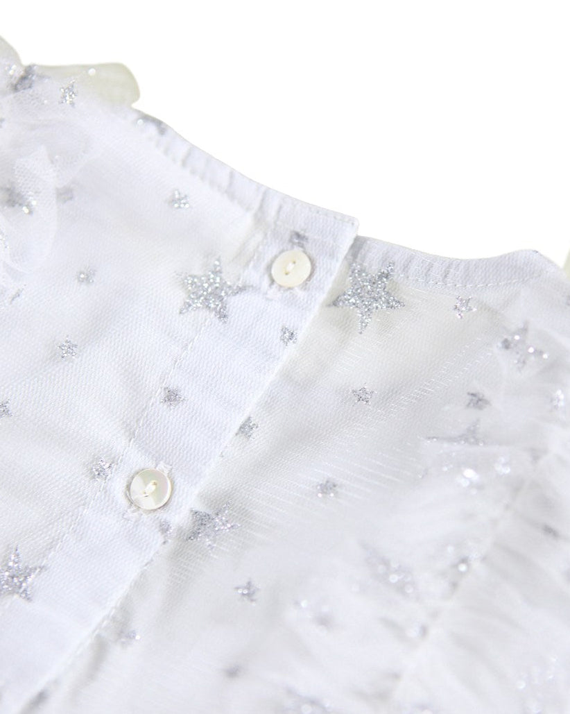 White blouse with star patterns and buttons on a white background
