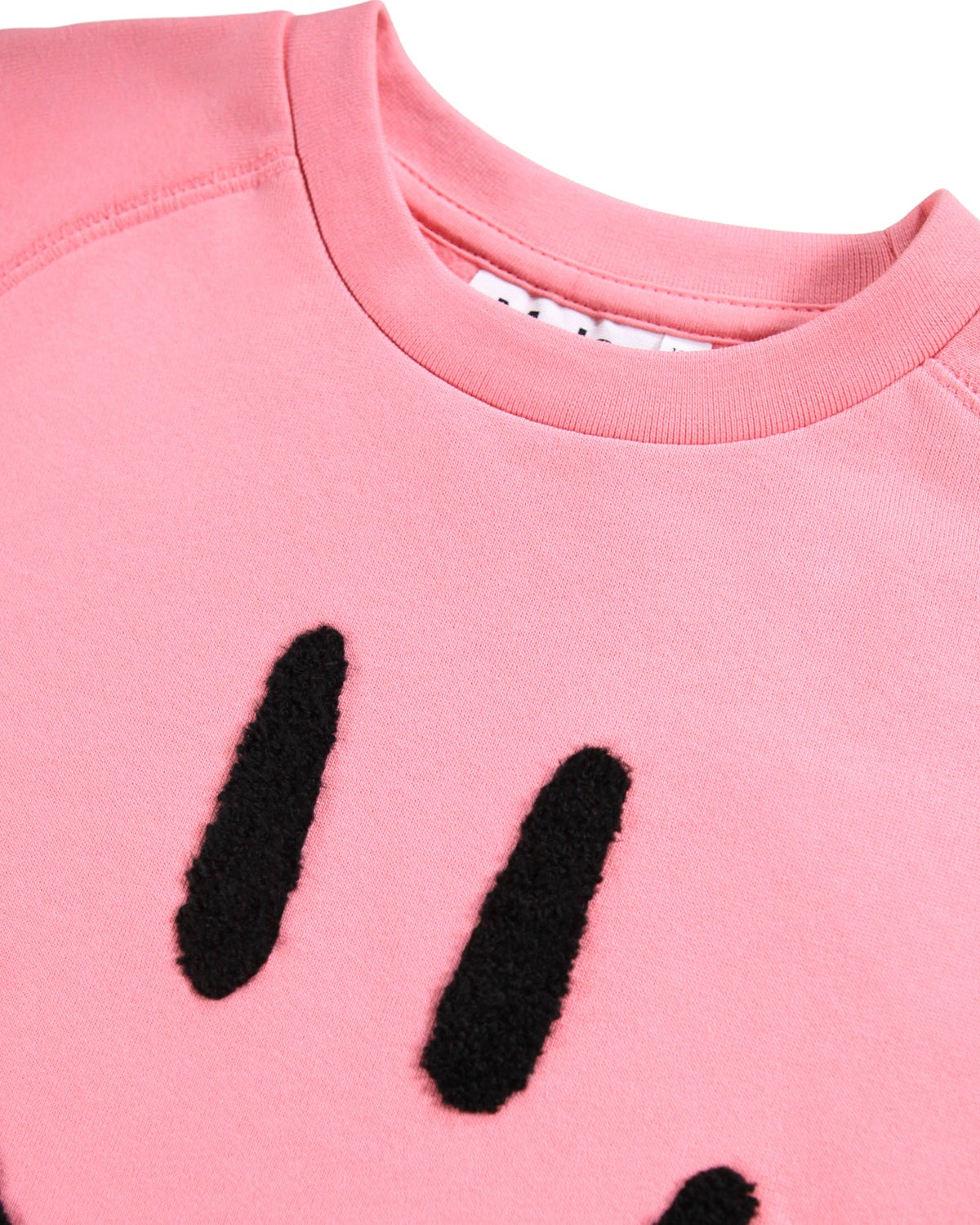Close-up of a pink sweatshirt with black paw print design on a white background