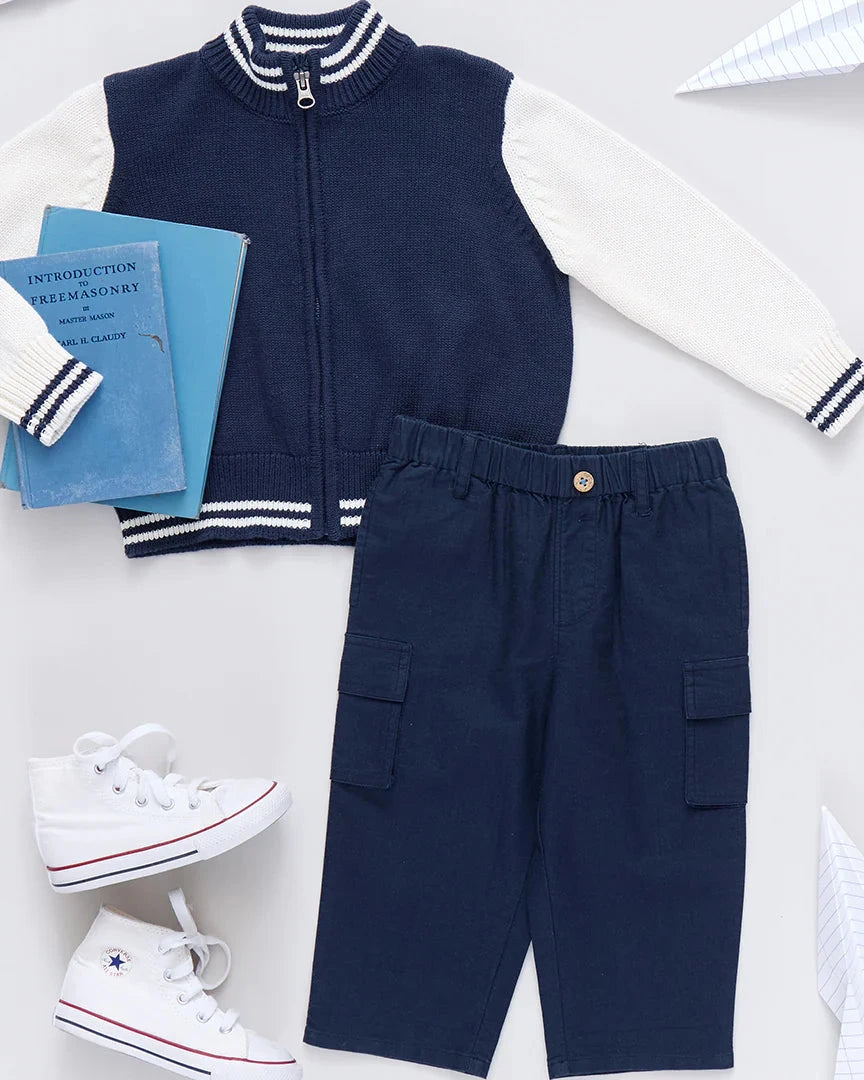 Navy and white children's outfit with books and sneakers on a light background