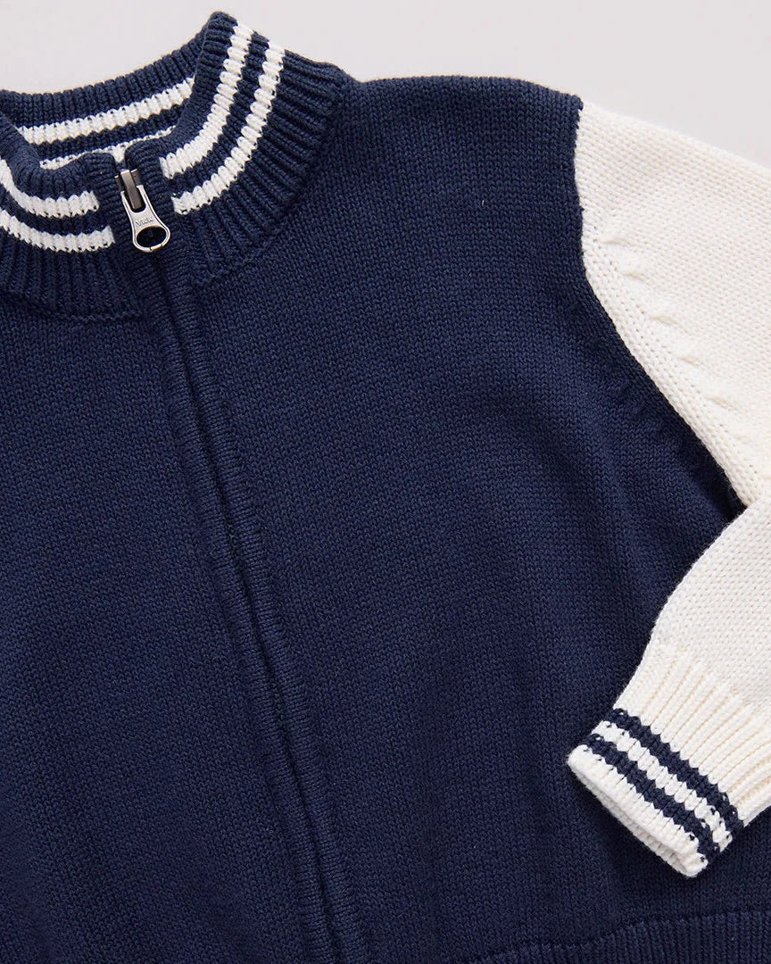 Navy blue and white sweater with a zipper on a light gray background
