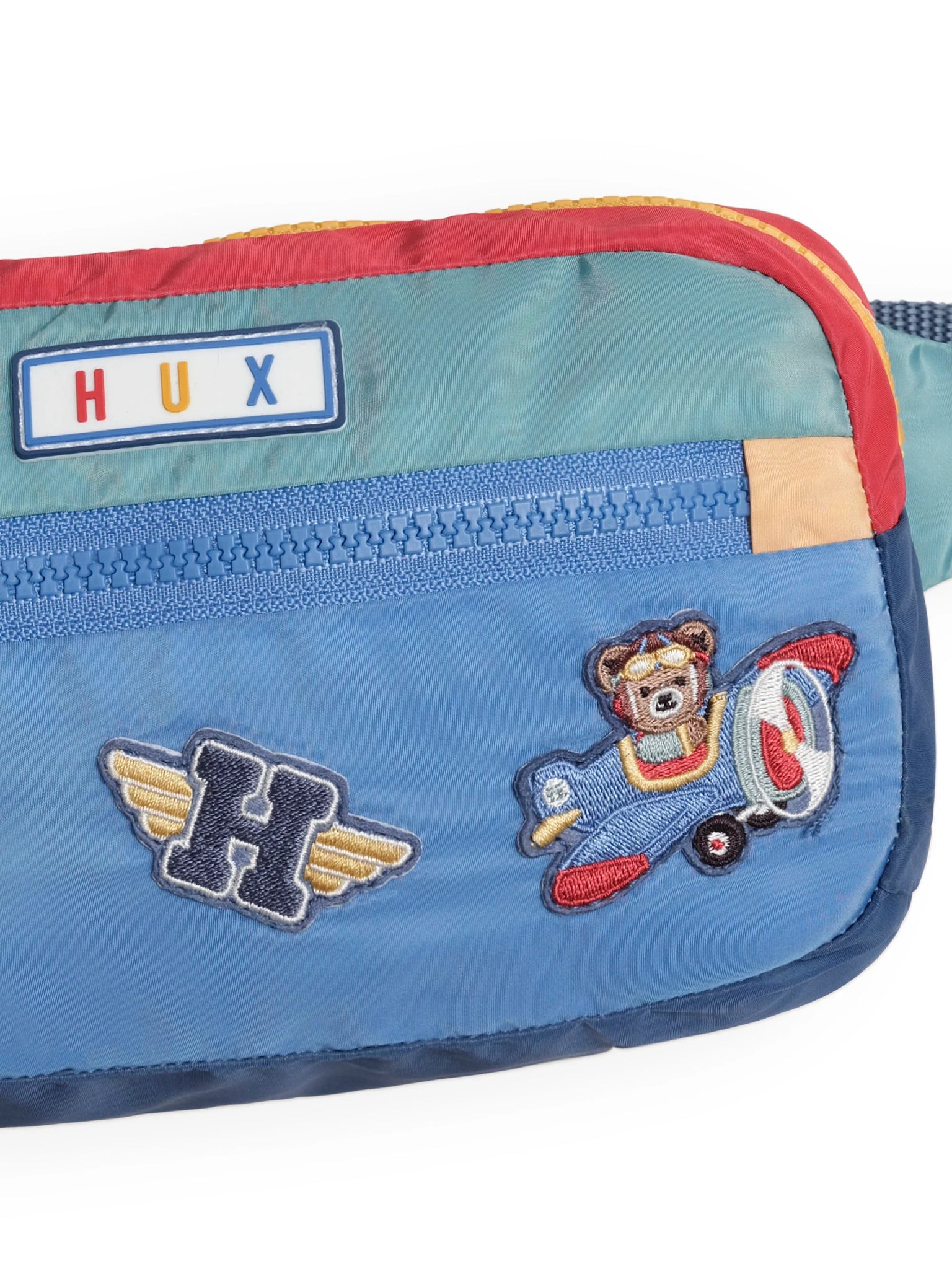 Blue pouch with bear on airplane design and HUX label