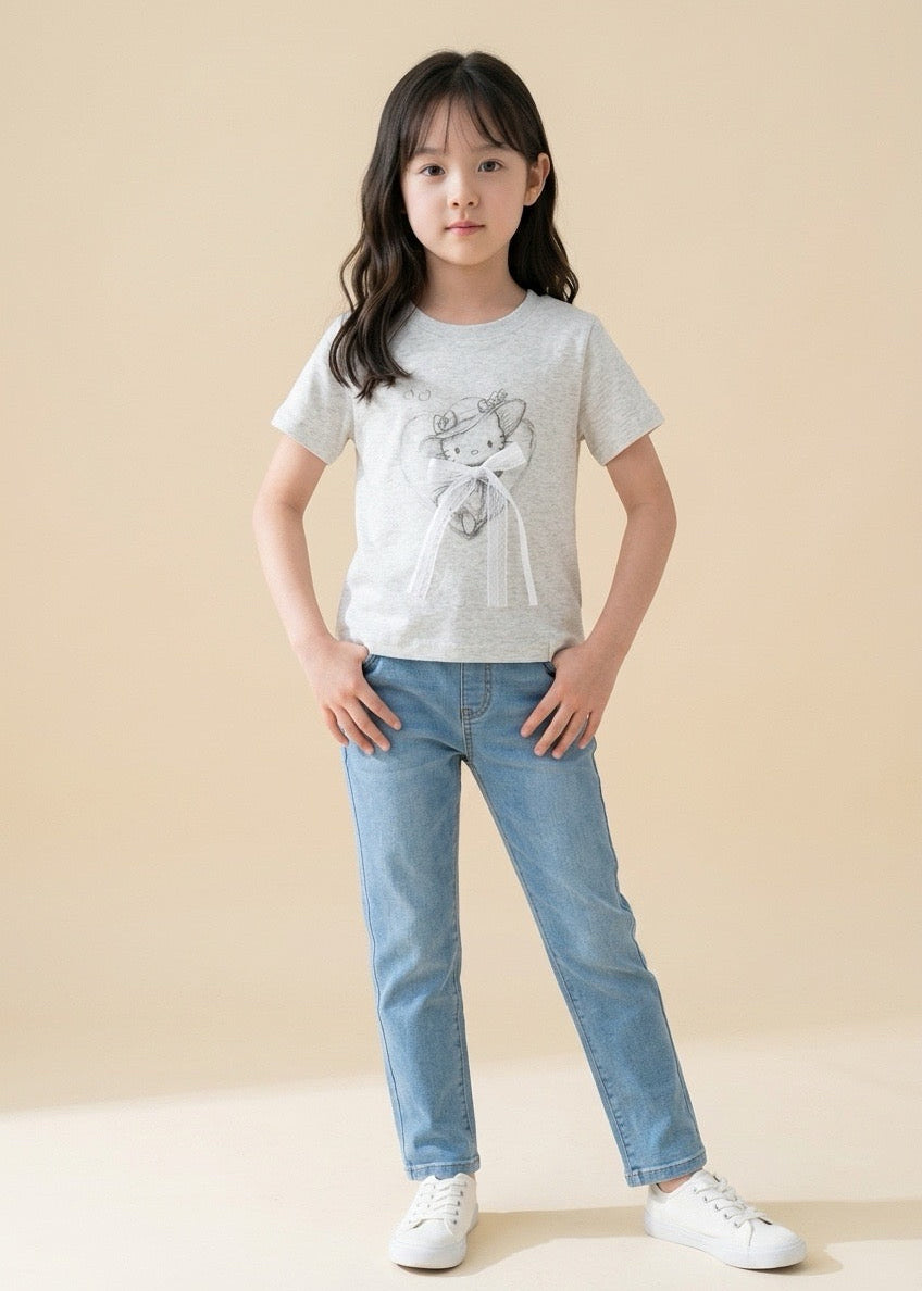 Young girl wearing a white t-shirt with a design and blue jeans on a beige background