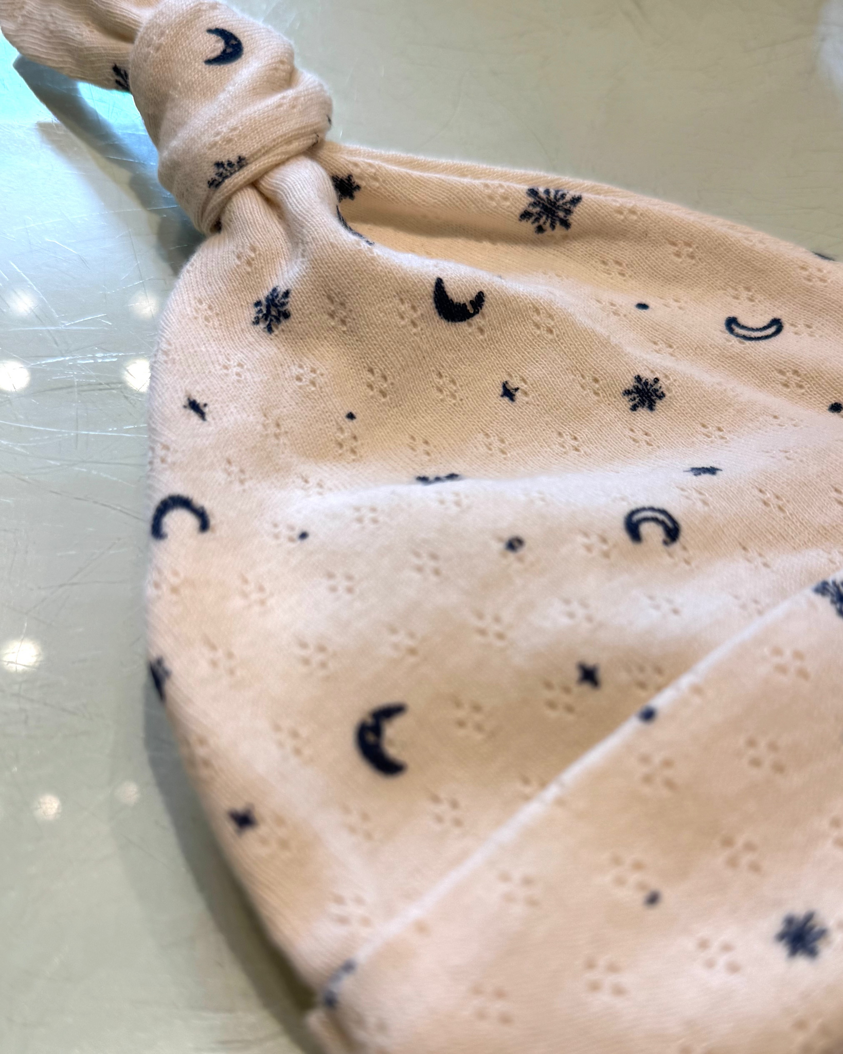 Beige fabric pouch with black moon patterns on a light background