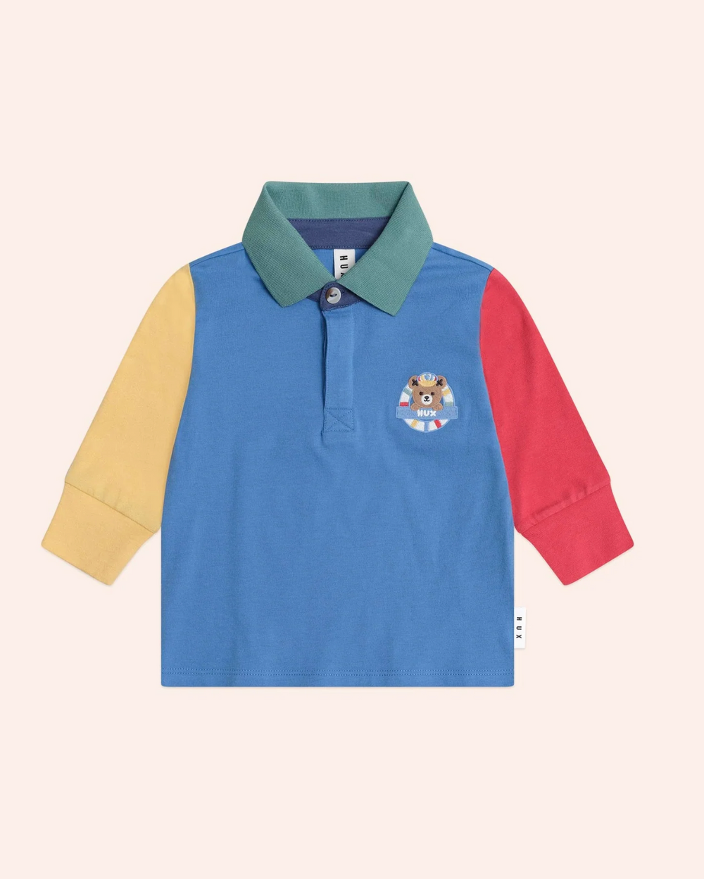 Color-blocked long-sleeve polo shirt with a brand logo on a light pink background