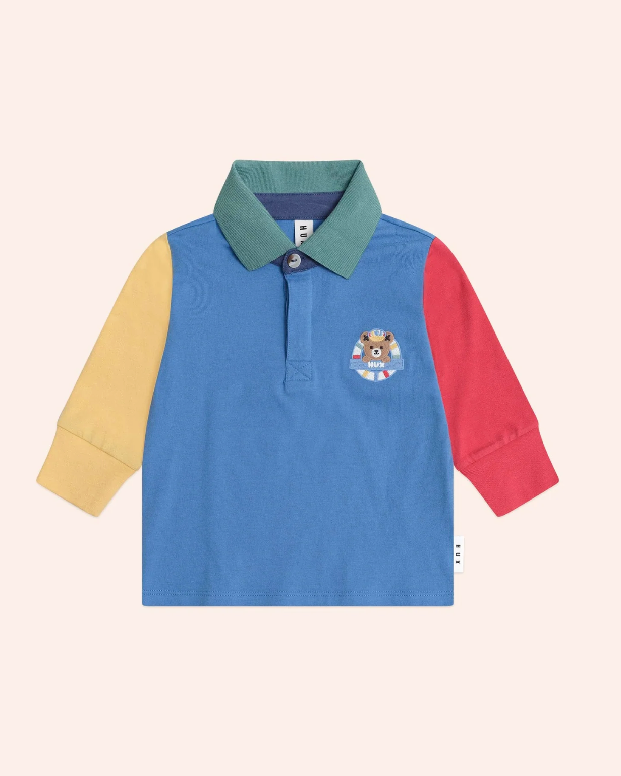 Color-blocked long-sleeve polo shirt with a brand logo on a light pink background