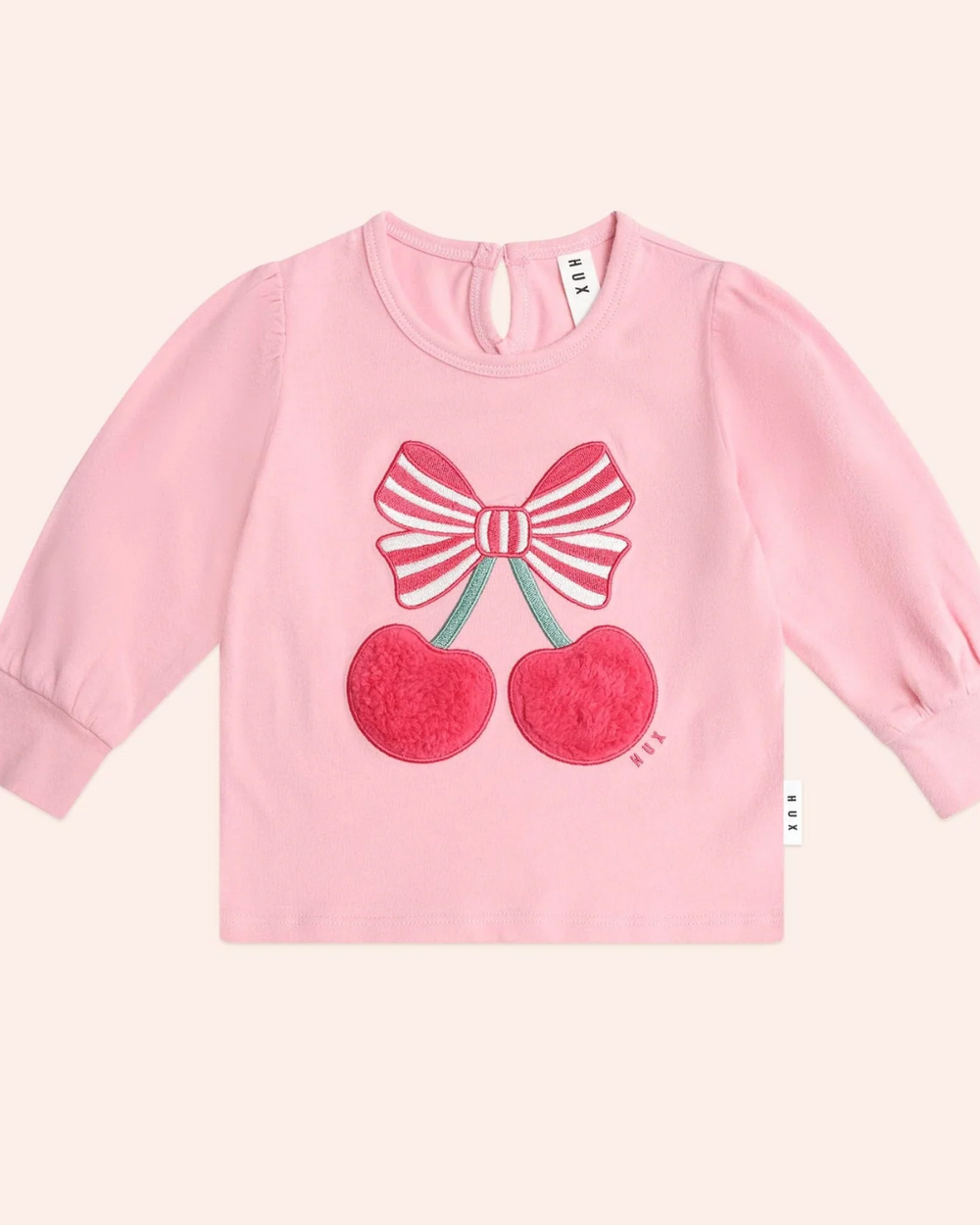 Pink sweatshirt with cherry and bow design on a white background