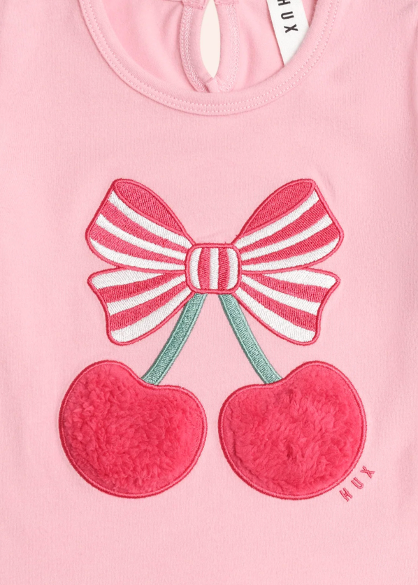 Pink shirt with a bow and cherry design, brand 'HUX' visible.