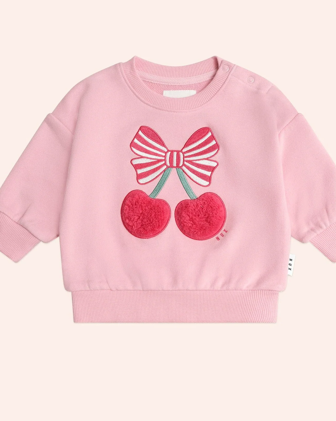 Pink sweatshirt with cherry and bow design on a light pink background