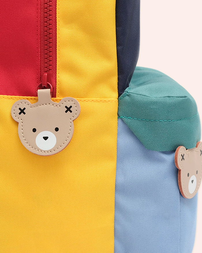 Colorful backpack with bear-shaped tags on a light background