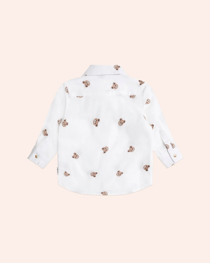 White shirt with decorative buttons on a light pink background