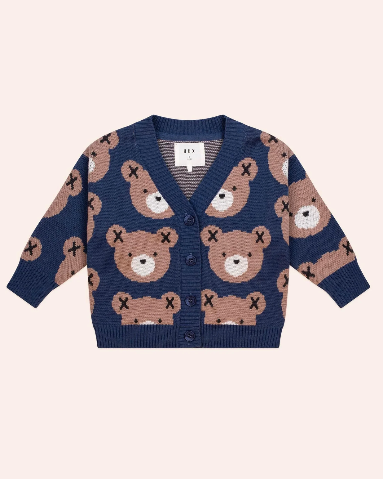 Navy blue cardigan with teddy bear pattern on a light pink background