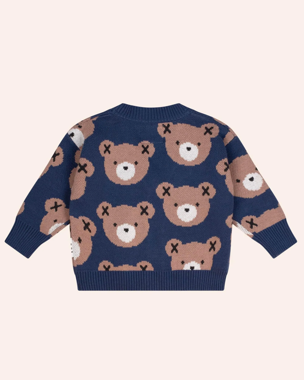 Navy blue sweater with teddy bear pattern on a light pink background