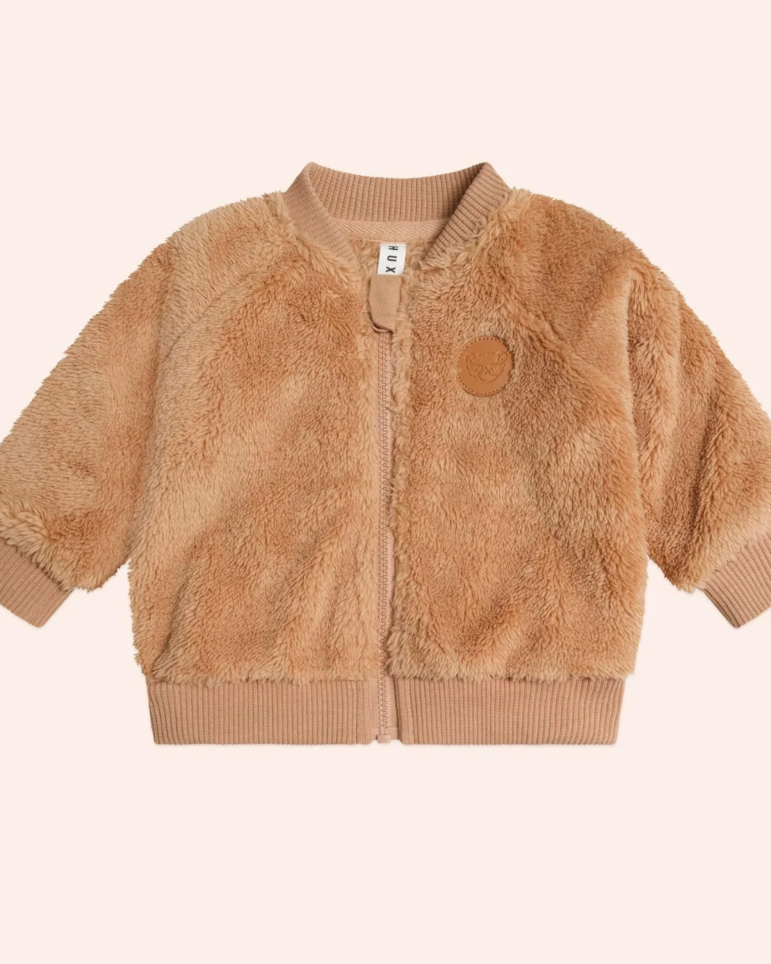 Brown fluffy jacket on a light pink background